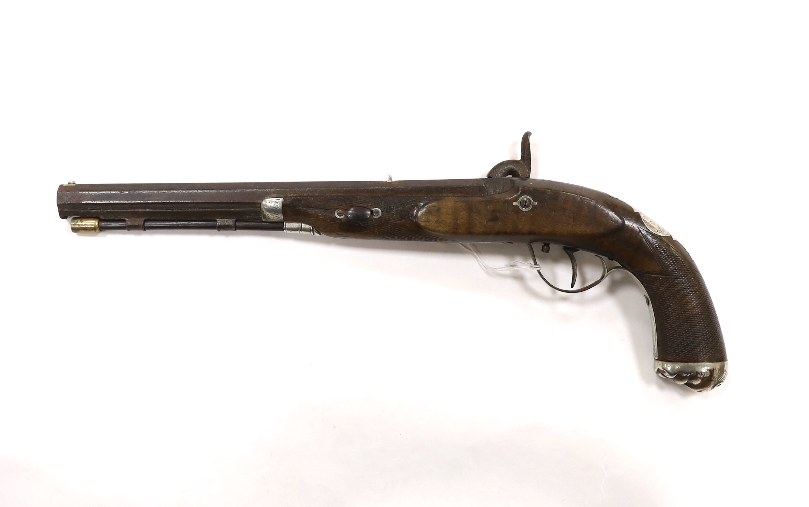 A 22 bore percussion holster pistol probably made for the Indian market, octagonal barrel with nickel sight, chequered walnut stock, engraved nickel furniture with grotesque mask butt cap
